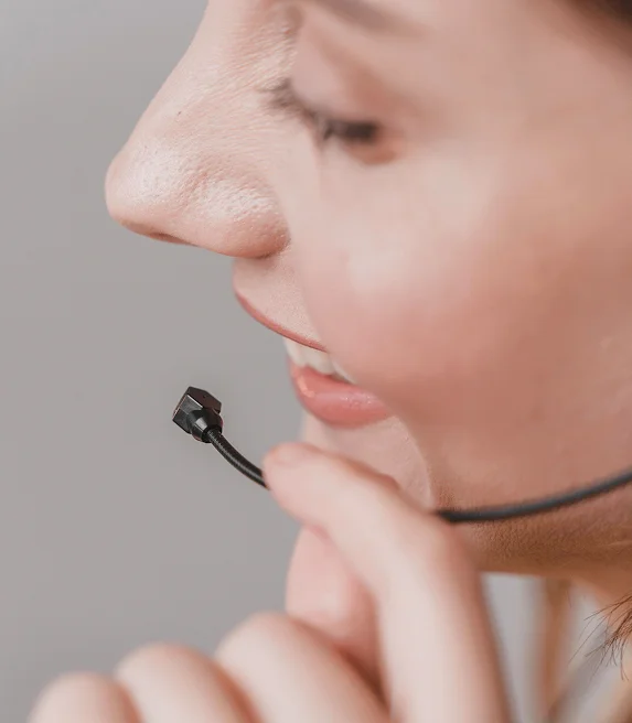Atendente da Biocarmim com headset auricular prestando suporte ao cliente sobre corantes naturais para a indústria alimentícia